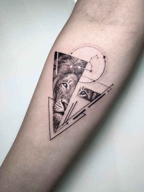 A black and grey geometric tattoo on the forearm featuring a realistic lion's face integrated with sacred geometry elements — by INKEDBy_G, los angeles