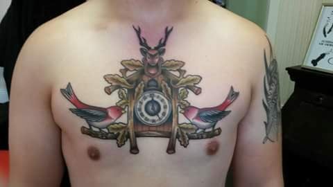 A colorful neo-traditional cuckoo clock tattoo on the chest with birds — by Samuel Connelly, san diego, ca