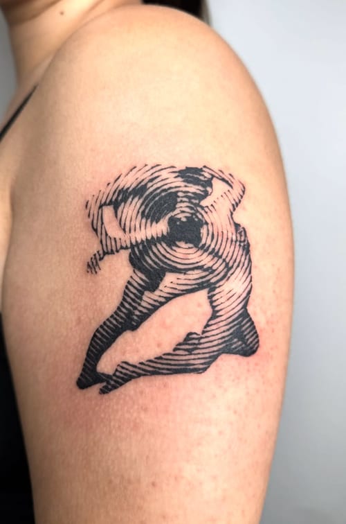 An abstract black and grey linework tattoo of a woman in motion on the upper arm, featuring dynamic lines and a sense of movement — by Level tattoo, los angeles