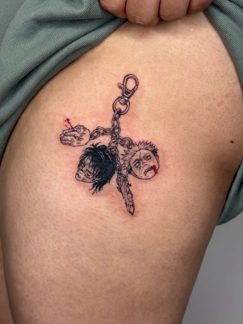 A fine line anime-style tattoo on the thigh depicting keychain charms with detailed faces and subtle red accents — by lunayflorestattoo, los angeles