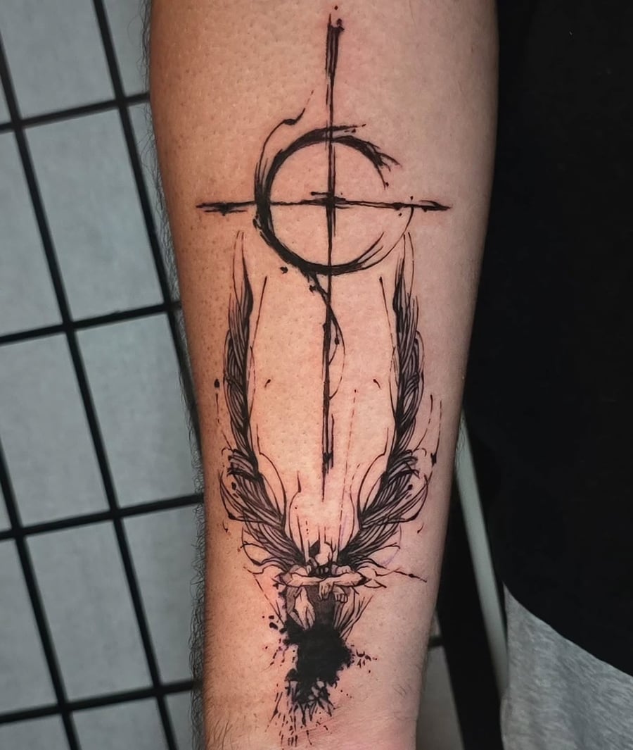 An abstract black and grey cross with wings tattoo on the forearm in a graphic Trash Polka style — by Miguel ANGELO, los angeles