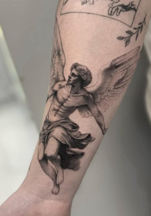 A black and grey realism tattoo of an angel on the forearm, featuring detailed shading and lifelike depiction — by otaybeatdown, los angeles