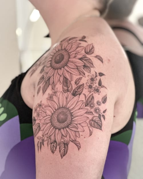 A delicate black and grey sunflower bouquet tattoo on the shoulder with intricate floral details — by Melanie Benoit, los angeles