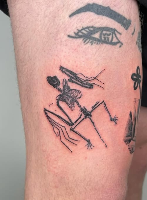An abstract black and grey linework tattoo of a skeleton on the thigh, featuring geometric elements and minimalistic design — by Level tattoo, los angeles