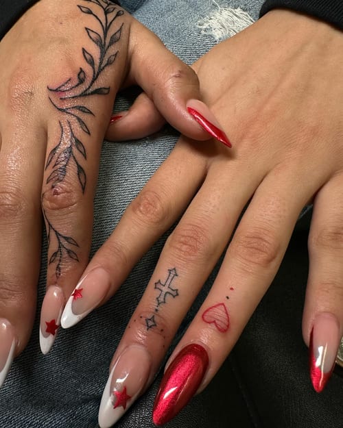 Delicate blackwork finger tattoos featuring leaves and symbols on the hand — by Maddie Ramirez, los angeles