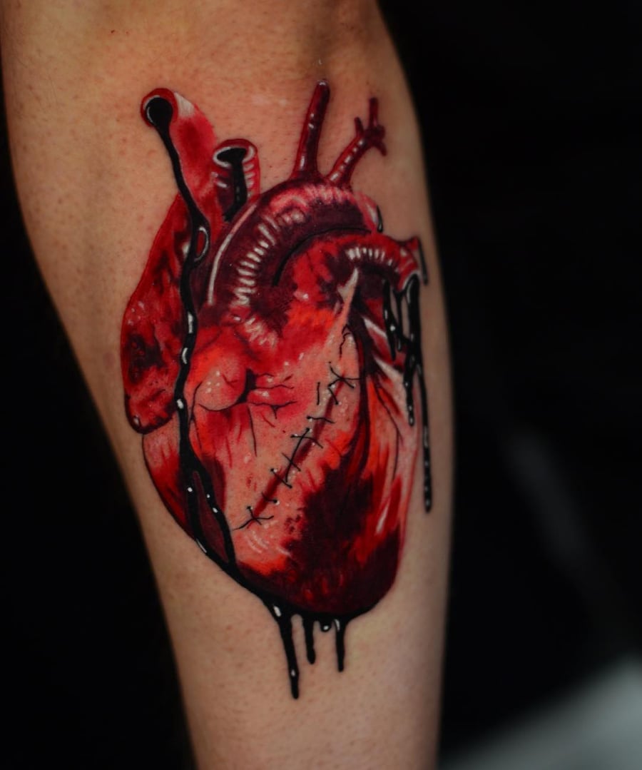 A bold and colorful anatomical heart tattoo on the forearm, featuring realistic details and graphic elements — by Johnny Ayala, los angeles