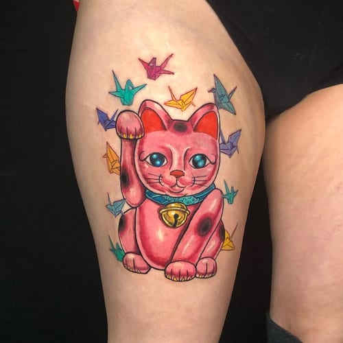 A colorful neo-traditional tattoo of a lucky cat surrounded by origami cranes on the thigh — by Sandra Price, los angeles
