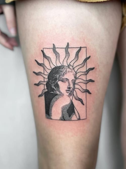 A black and grey tattoo on the thigh featuring a portrait with sun rays in a blackwork and dotwork style — by Level tattoo, los angeles