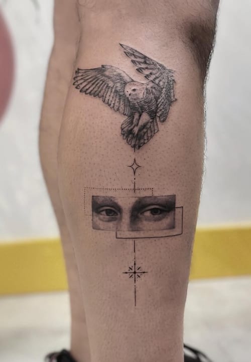A black and grey illustrative tattoo on the calf featuring a detailed owl in flight above a geometric design with a pair of eyes and a star-like symbol — by Jian Liang, los angeles