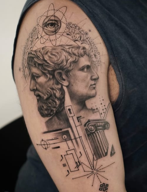 A black and grey tattoo on the upper arm featuring two realistic mythological profiles, geometric elements, and an eye within an atomic symbol — by Jian Liang, los angeles
