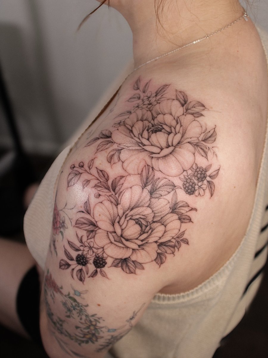 A delicate black and grey floral bouquet tattoo on the shoulder with intricate botanical details — by Melanie Benoit, los angeles