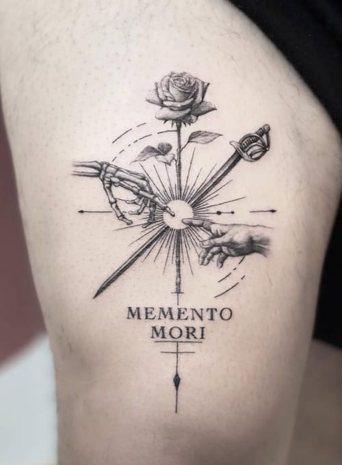 A black and grey fine line tattoo on the thigh featuring a rose, a skeleton hand, a human hand, a sword, and the quote 'Memento Mori' — by Jian Liang, los angeles