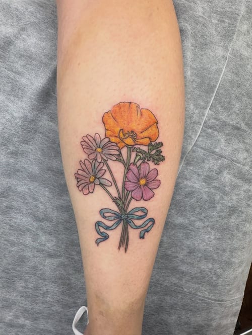 A colorful bouquet of flowers tattooed on the forearm in a fine line style, featuring delicate floral details — by Sandra Price, los angeles