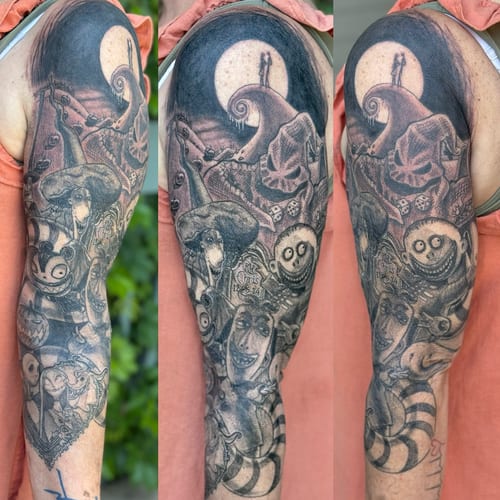 A black and grey sleeve tattoo featuring characters from a movie with a dark and graphic style on the upper arm — by Sandra Price, los angeles