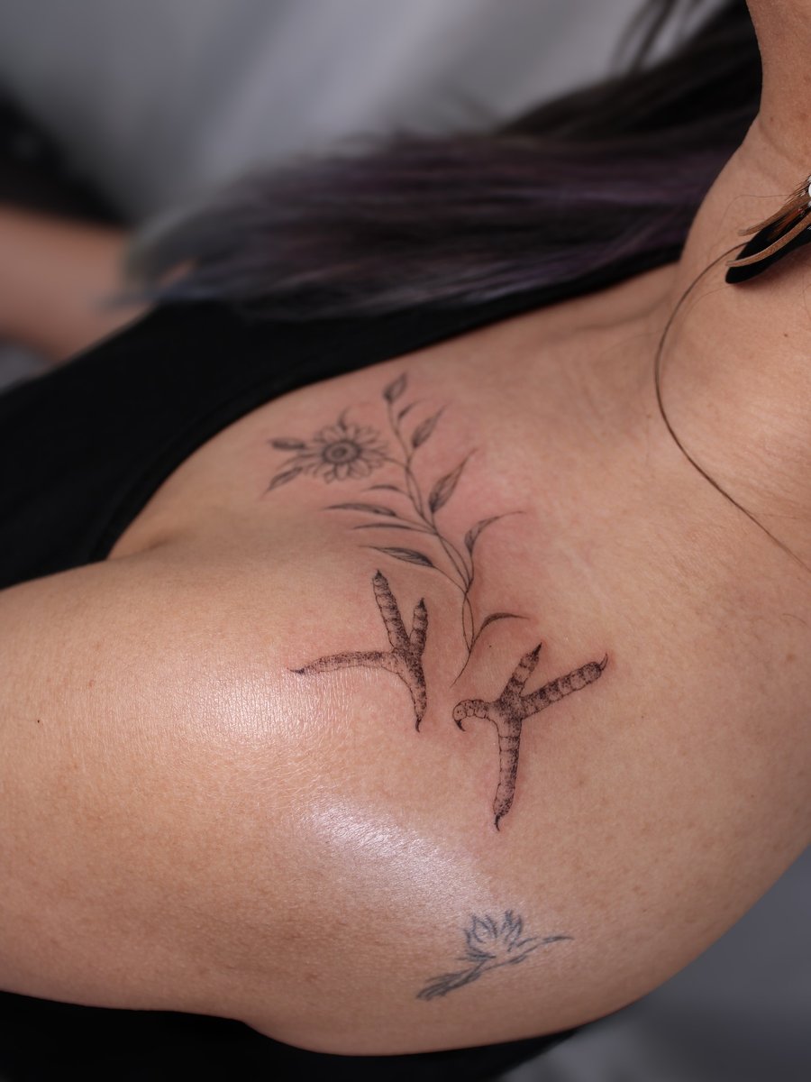 A delicate black and grey tattoo of birds and a flower on the shoulder, featuring fine line work and minimalistic design — by Melanie Benoit, los angeles