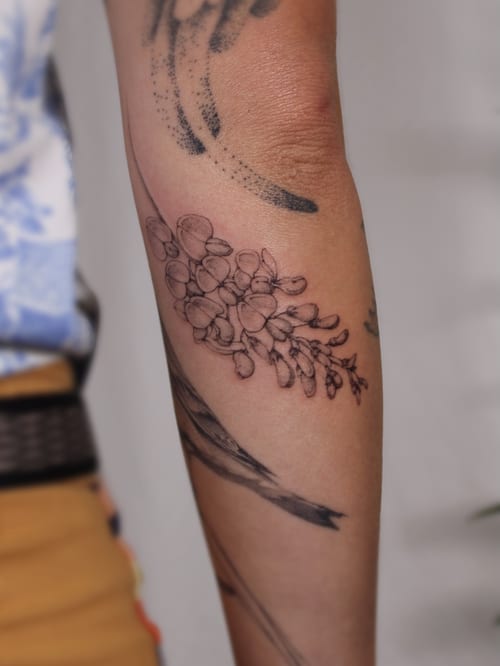 A delicate black and grey fine line flower bouquet tattoo on the forearm — by Melanie Benoit, los angeles