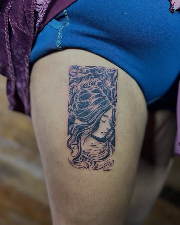 A delicate black and grey woman's portrait tattoo on the thigh with flowing hair and ornate detailing — by Dylan Aiello, los angeles