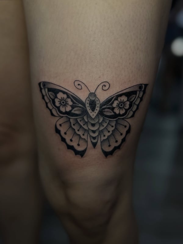 A bold blackwork butterfly tattoo with ornamental details on the leg — by Maddie Ramirez, palm desert, ca