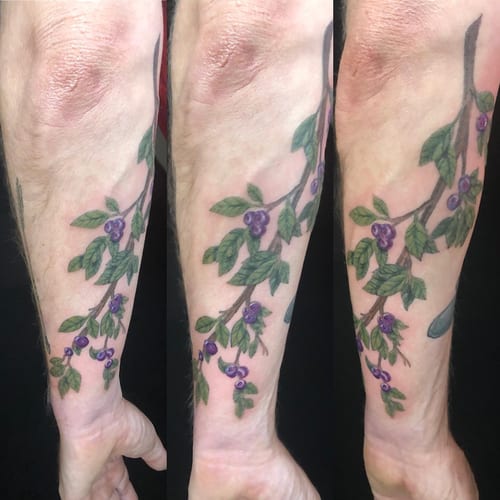 A colorful botanical tattoo of a branch with berries on the forearm, featuring delicate illustrative style — by Sandra Price, los angeles