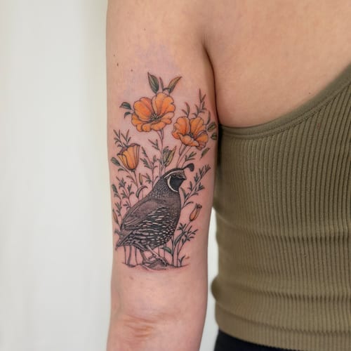 A delicate illustrative tattoo of a quail surrounded by orange flowers on the upper arm, featuring fine line work and a mixed color palette — by Melanie Benoit, los angeles