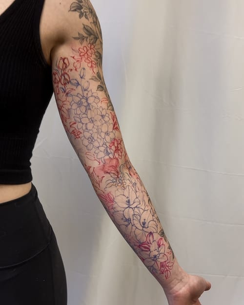 A delicate floral sleeve tattoo on the arm featuring intricate linework and colorful flowers — by Melanie Benoit, los angeles