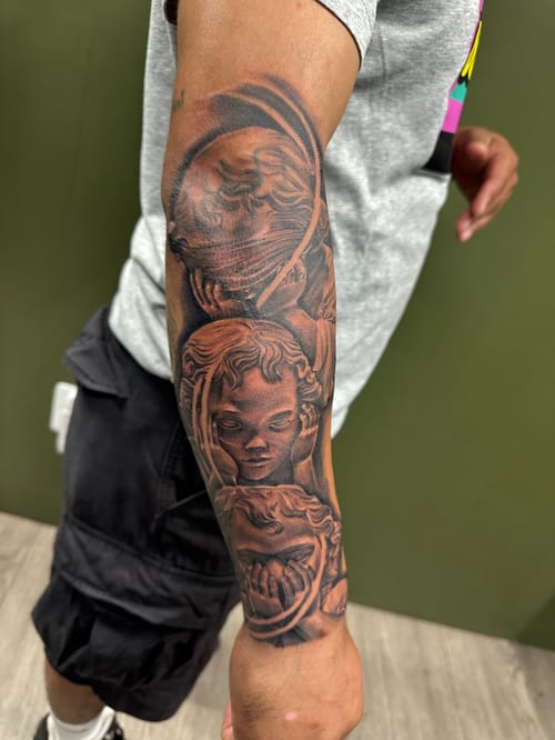 A black and grey realism tattoo on the forearm depicting an angelic figure with detailed shading and depth — by Humilde tattoos, los angeles