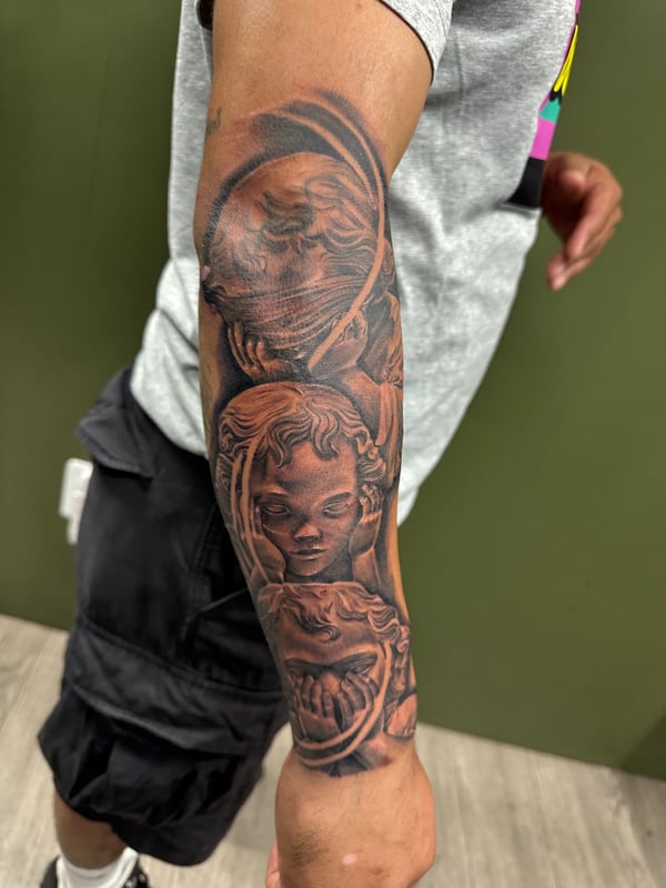 A black and grey realism tattoo on the forearm depicting an angelic figure with detailed shading and depth — by Humilde tattoos, los angeles