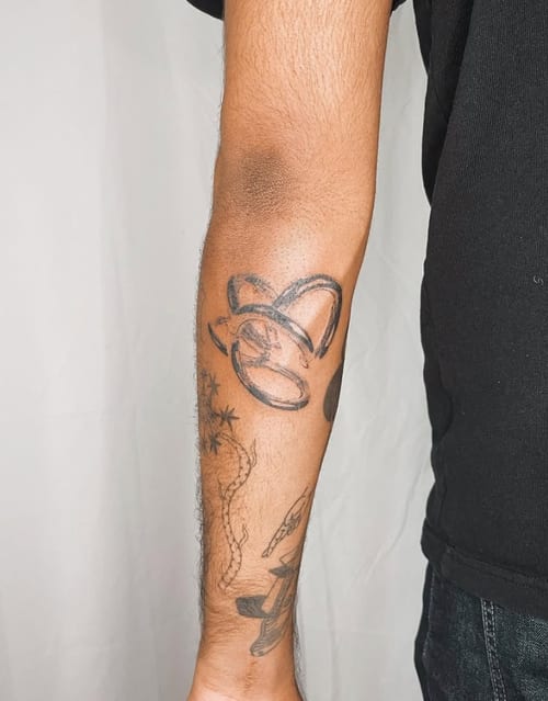 A minimalist black and grey abstract design on the forearm, featuring simple linework and geometric shapes — by Level tattoo, los angeles
