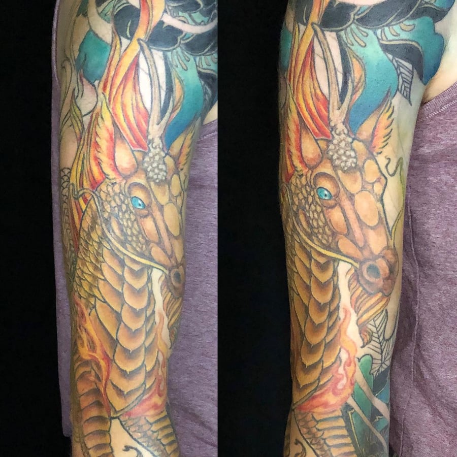 A colorful Japanese dragon tattoo covering the full sleeve with bold and ornate details — by Sandra Price, los angeles