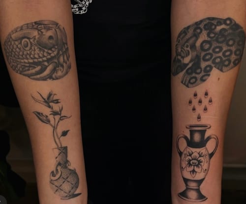 A set of black and grey illustrative tattoos on the forearms, featuring a snake, floral elements, and vases with intricate patterns — by velvet devil, los angeles