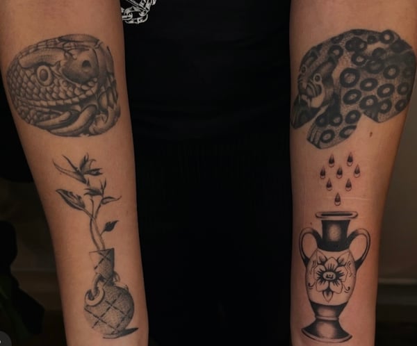 A set of black and grey illustrative tattoos on the forearms, featuring a snake, floral elements, and vases with intricate patterns — by velvet devil, los angeles