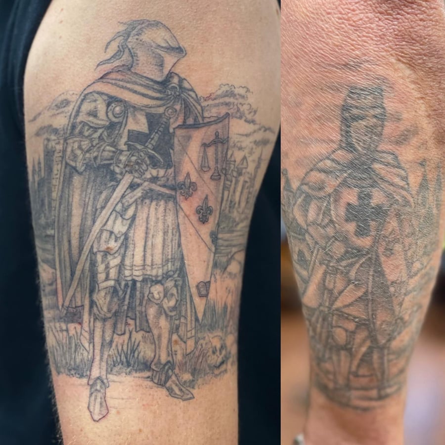 A detailed black and grey tattoo of a knight in armor holding a sword and shield on the upper arm — by Sandra Price, los angeles