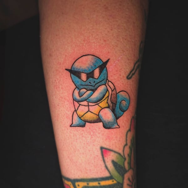 A colorful tattoo of Squirtle from Pokemon on the leg, featuring a whimsical cartoon style — by Miguel ANGELO, temecula, ca
