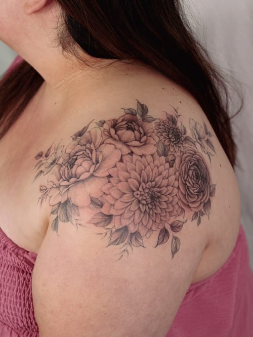 A delicate black and grey floral bouquet tattoo on the shoulder with intricate details and shading — by Melanie Benoit, los angeles