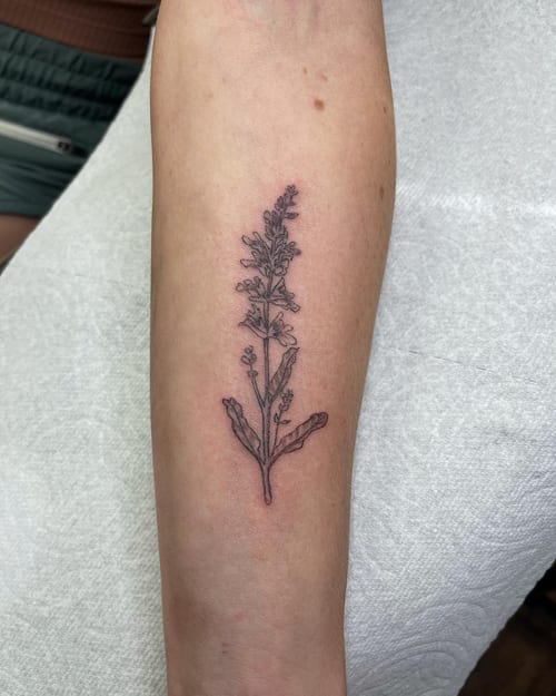 A delicate fine line tattoo of a lavender sprig on the forearm, done in black and grey — by Sandra Price, los angeles
