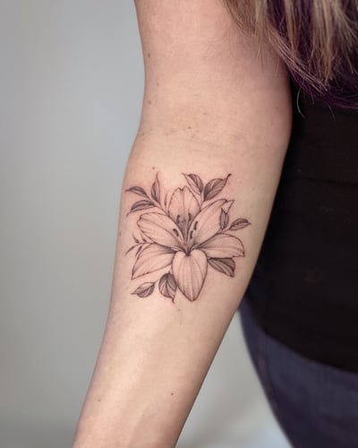 A delicate black and grey lily flower tattoo on the forearm with fine line detailing — by Melanie Benoit, los angeles
