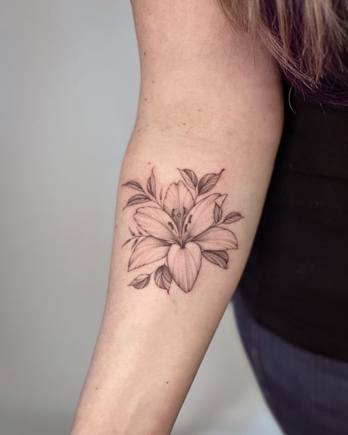 A delicate black and grey lily flower tattoo on the forearm with fine line detailing — by Melanie Benoit, los angeles