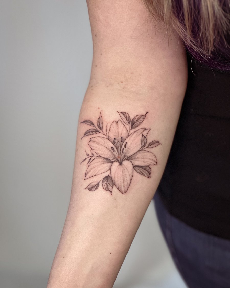 A delicate black and grey lily flower tattoo on the forearm with fine line detailing — by Melanie Benoit, los angeles