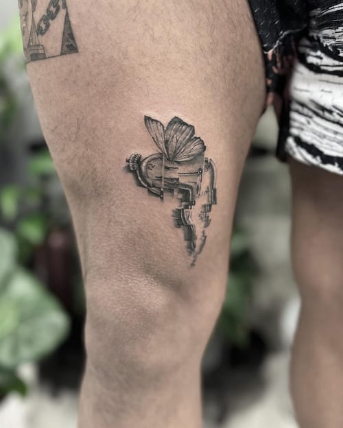 A black and grey surrealistic tattoo of a melting clock with a butterfly on the thigh, blending realism and surrealism — by Jian Liang, los angeles