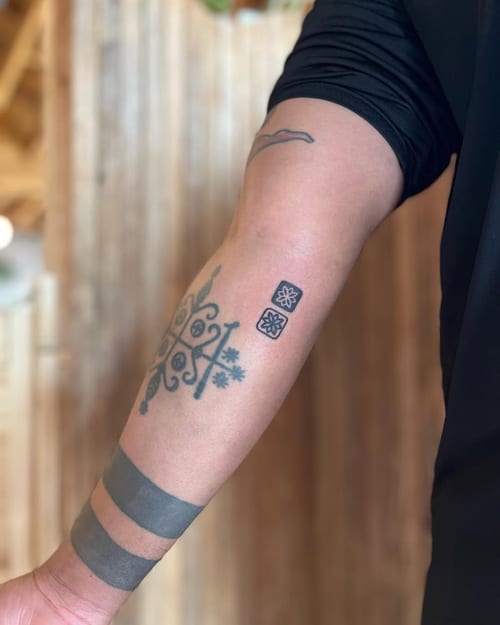 A minimalist black and grey geometric pattern tattoo on the forearm with bold lines and sacred geometry elements — by Dylan Aiello, los angeles