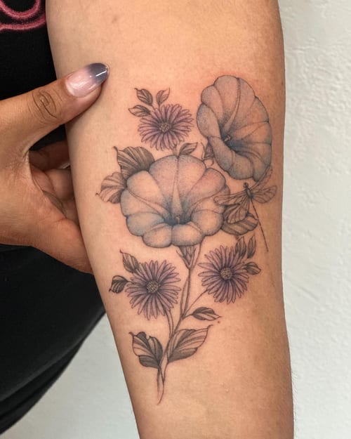 A delicate black and grey floral arrangement tattoo on the forearm, featuring fine line work and detailed flowers — by Melanie Benoit, los angeles