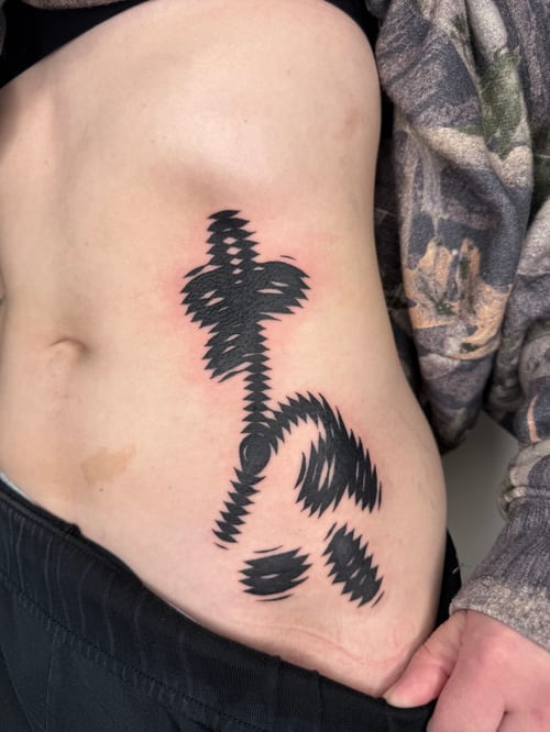bold abstract blackwork with jagged, vibrating edges flowing down the ribs and hip — by level tattoo, los angeles