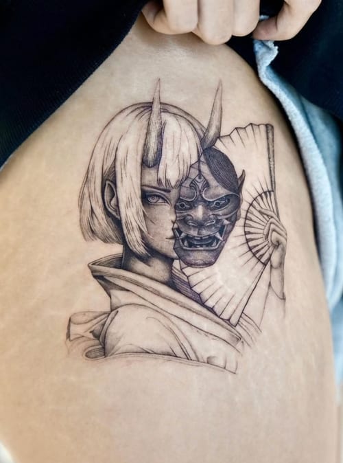 A black and grey tattoo on the thigh depicting a woman with a traditional Japanese mask, featuring detailed linework and shading — by otaybeatdown, los angeles