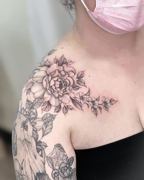A delicate black and grey floral bouquet tattoo on the shoulder with intricate detailing and shading — by Melanie Benoit, los angeles