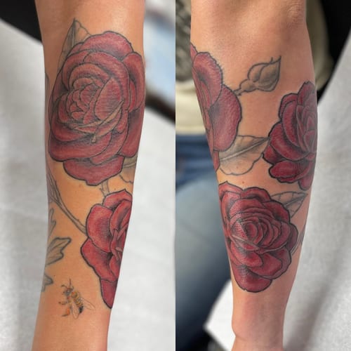 A bold neo-traditional tattoo featuring red roses and a bee on the forearm — by Sandra Price, los angeles