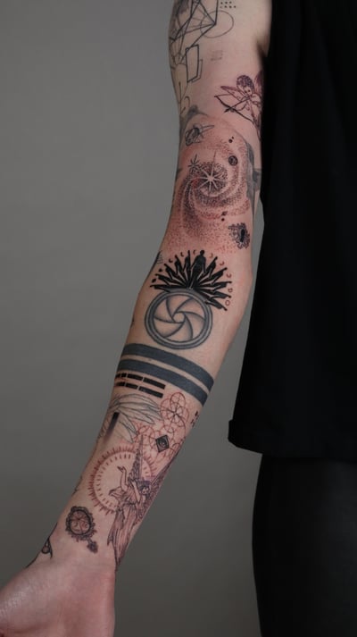 A black and grey geometric and dotwork tattoo on the forearm featuring sacred geometry elements, a sun, and a moon — by Vince Espinoza, los angeles
