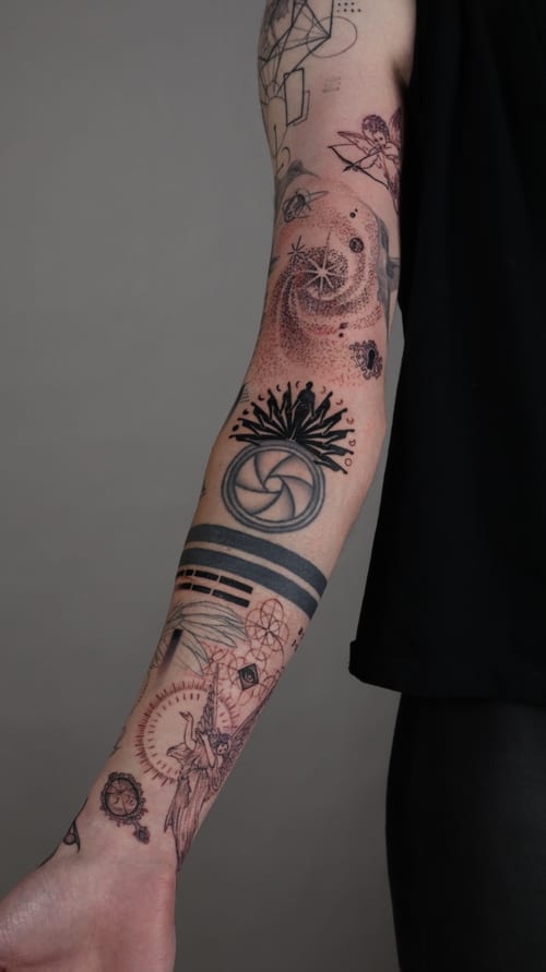 A black and grey geometric and dotwork tattoo on the forearm featuring sacred geometry elements, a sun, and a moon — by Vince Espinoza, los angeles