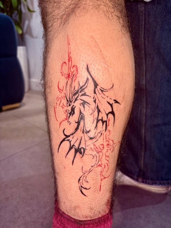 A bold black and red dragon tattoo on the calf with graphic and illustrative elements — by Hannah , fountain valley, ca