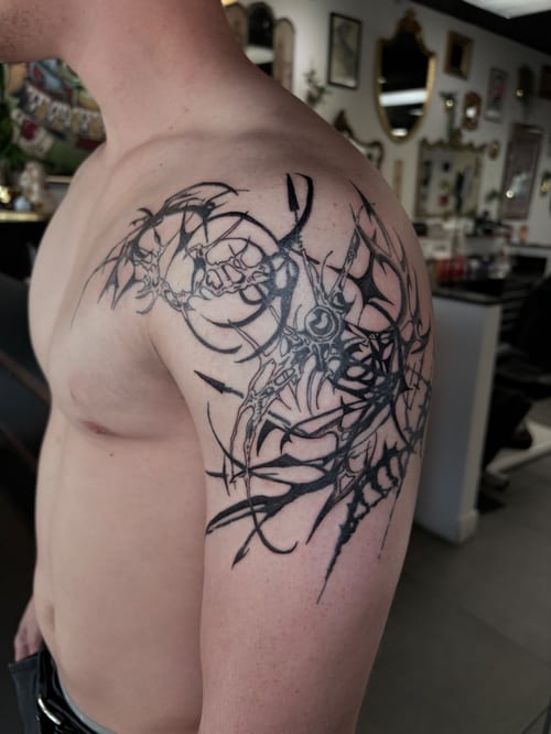 abstract blackwork shoulder tattoo of sweeping spikes and weblike linework — by hannah, los angeles