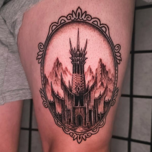 A black and grey tattoo of a dark tower with surrounding mountains on the thigh, featuring intricate blackwork and illustrative style — by Miguel ANGELO, temecula, ca